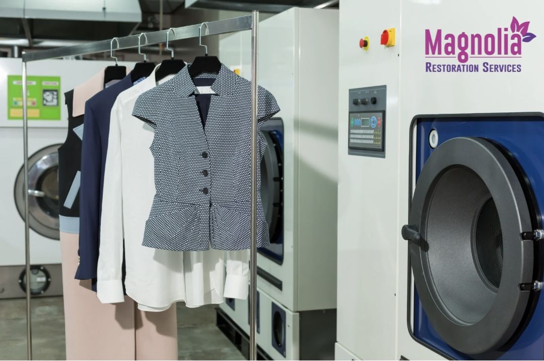 Cleaned business apparel on a rack beside commercial washers