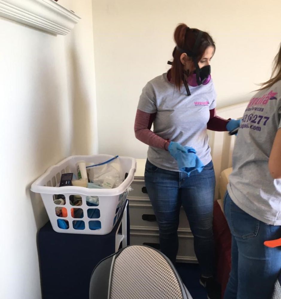 Magnolia technicians in respirators and gloves cleaning a room