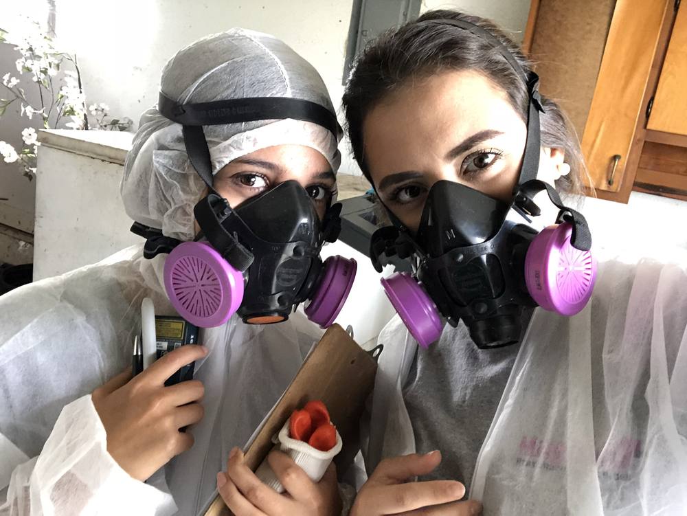 Two Magnolia technicians in respirators and protective suits