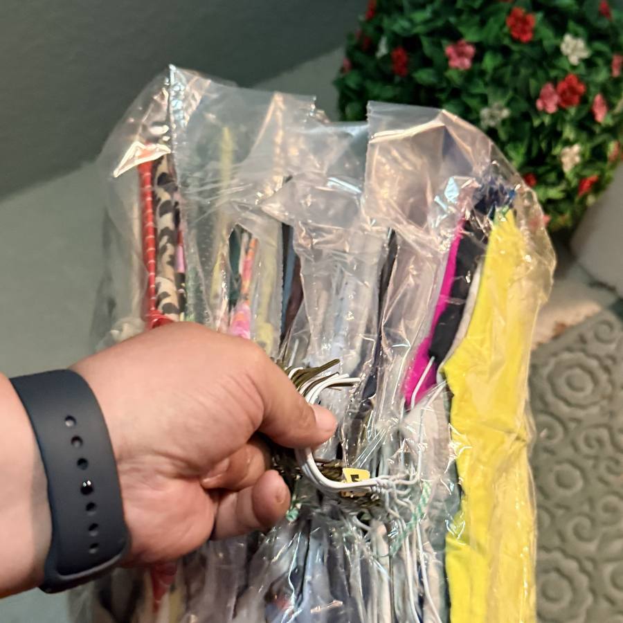 Bundle of bagged clothing on hangers