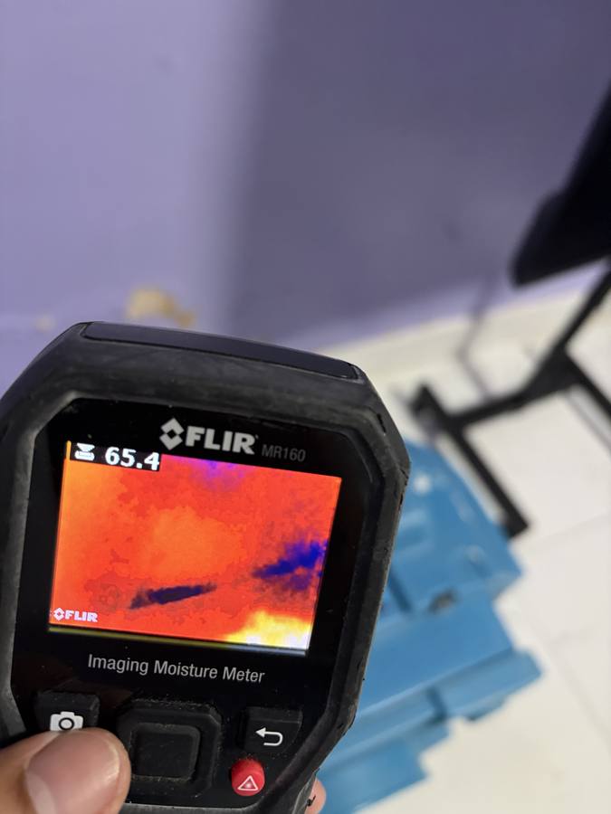 Checking a ceiling stain with a thermal moisture meter